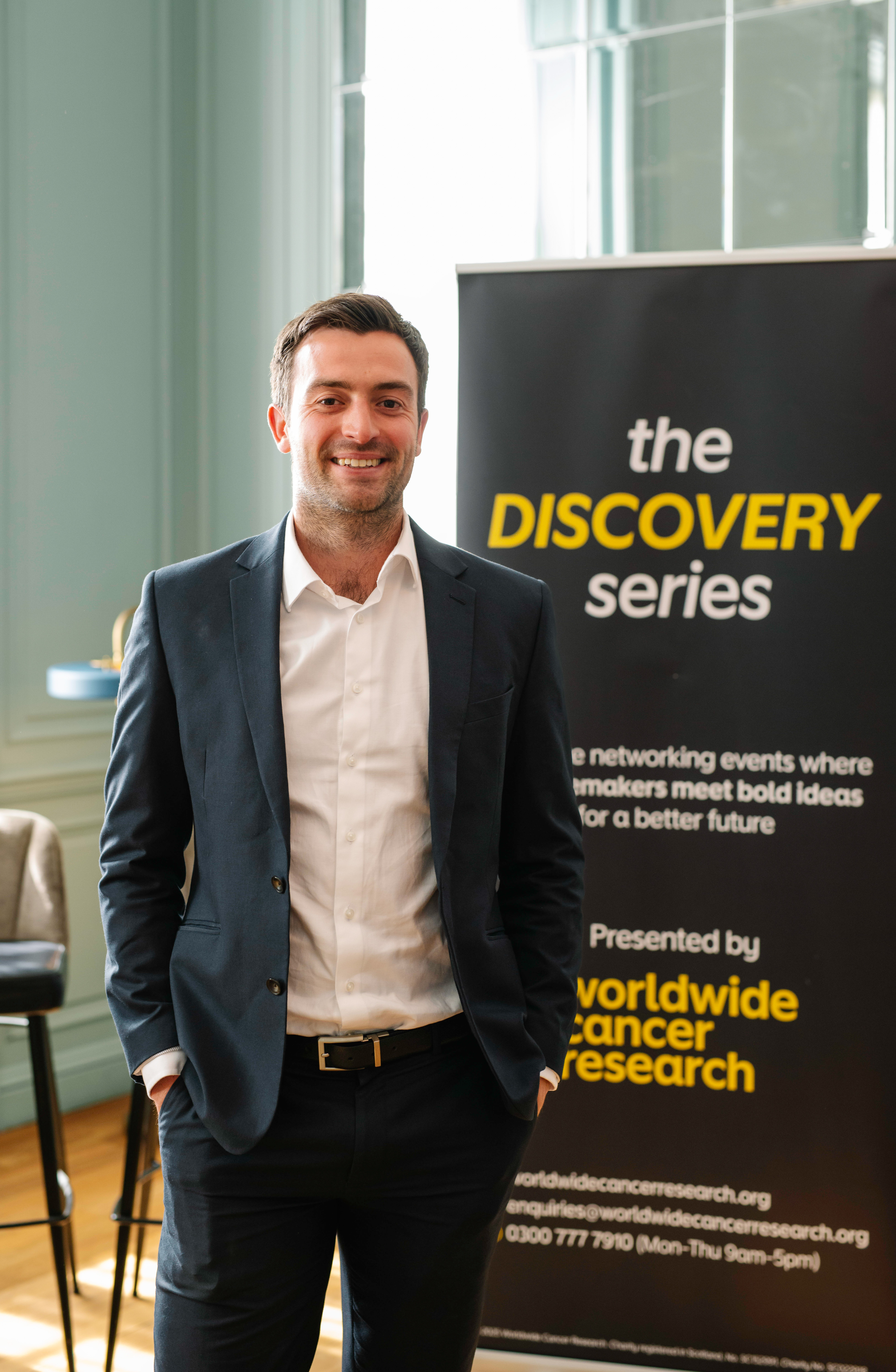 An image of our Philanthropy Manager Euan MacNeish smiling in a suit, at our Philanthropy Discovery Series event in Edinburgh