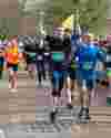 Runners cheering and smiling in the Bath Half Marathon