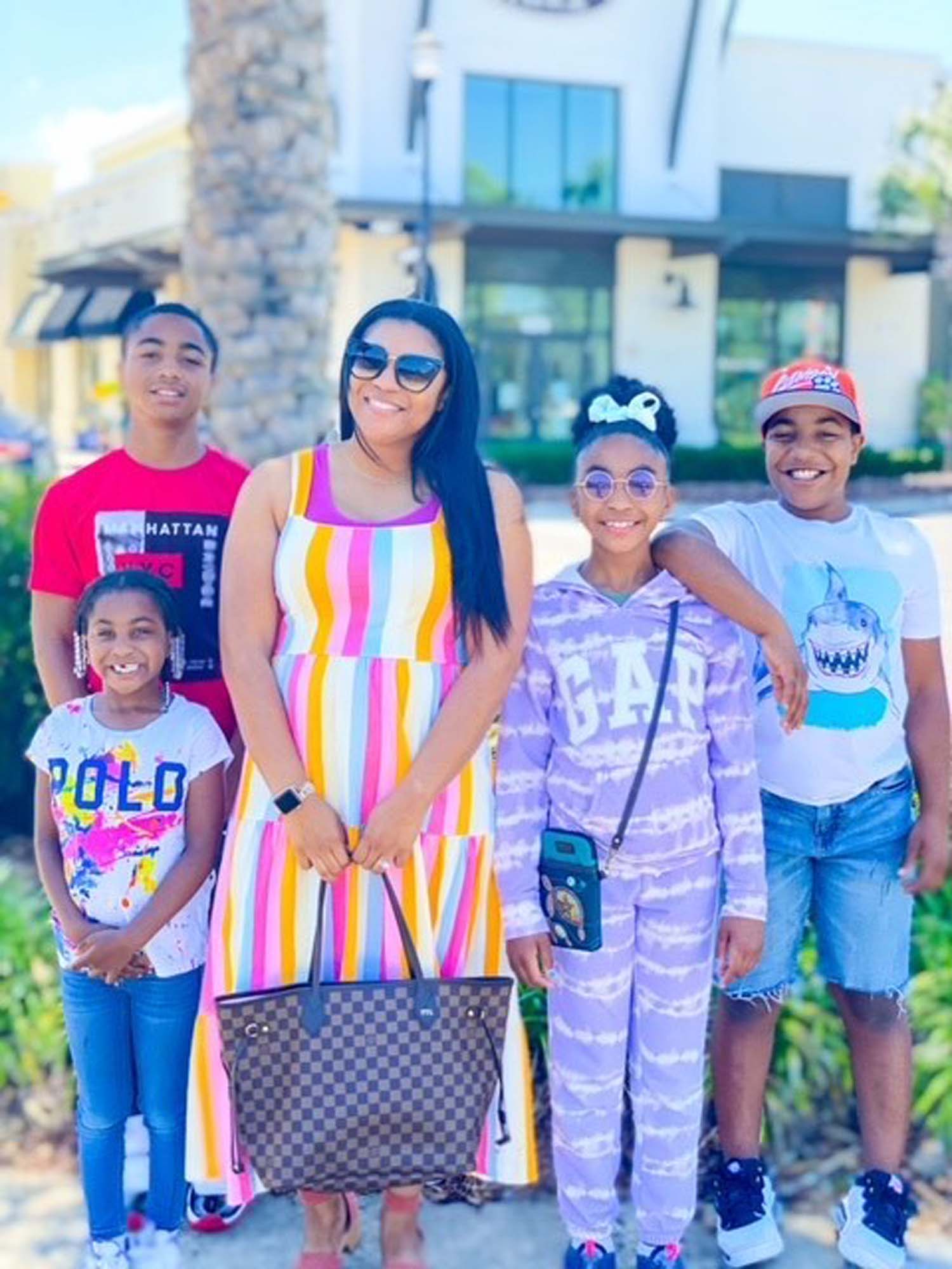 Tamron Little and her family smile for a photo together in the sunshine