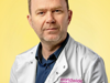 An image of Dr Niall Kenneth wearing a lab coat against a yellow background